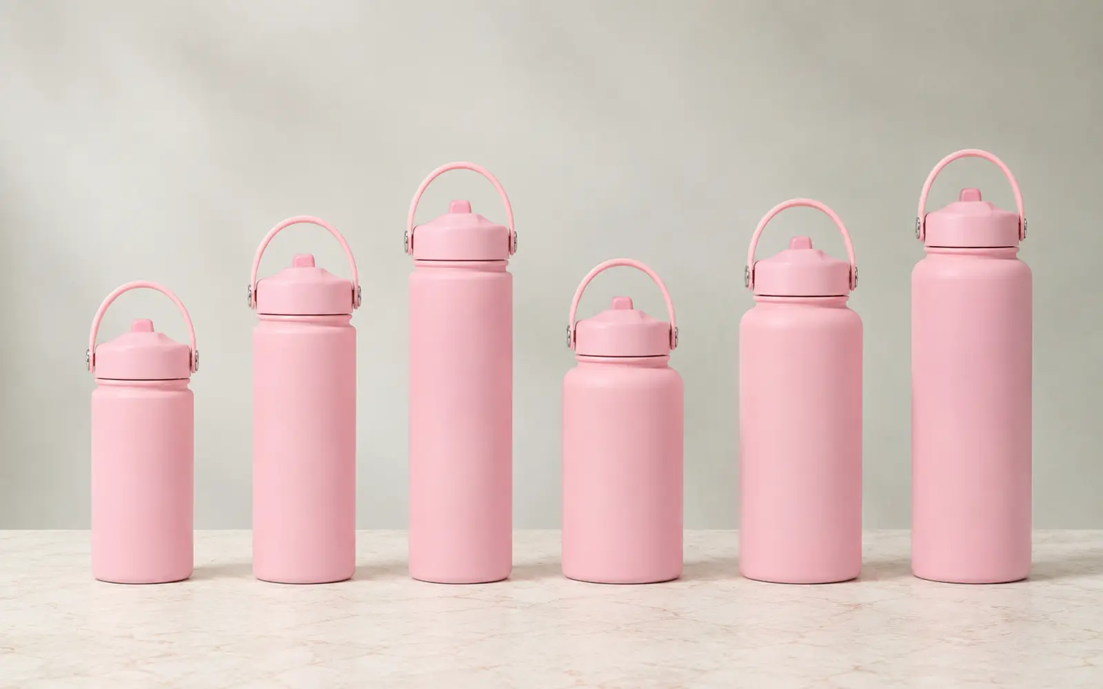 Pink sports bottles in six sizes with handle caps.
